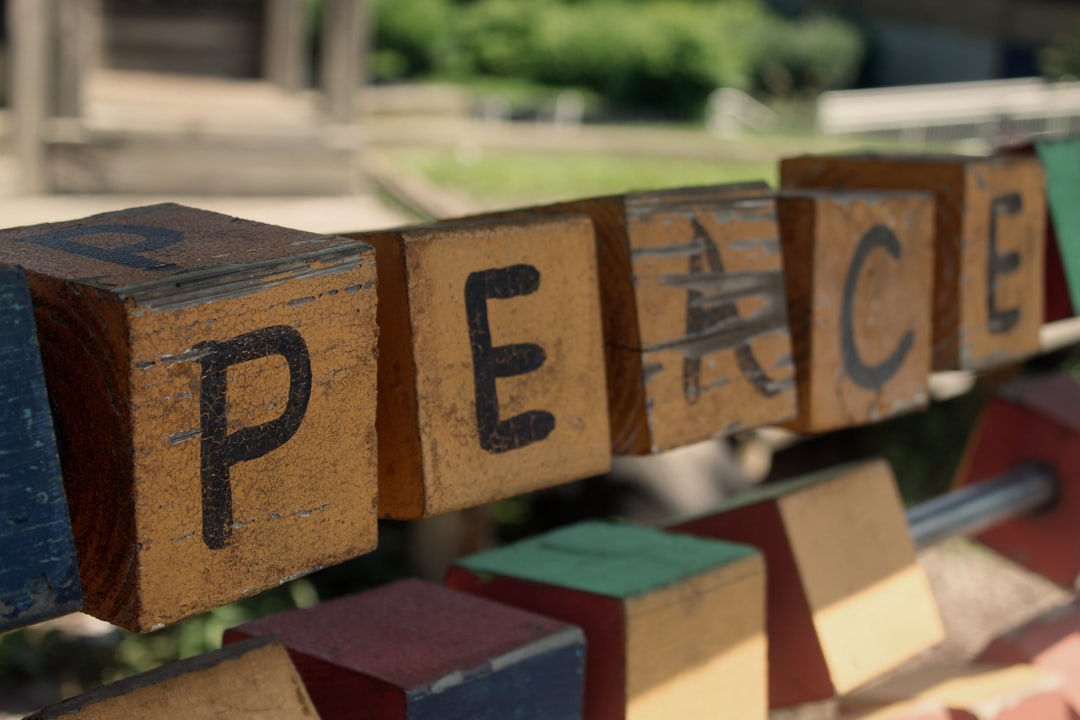Wooden blocks spelling peace on a bench