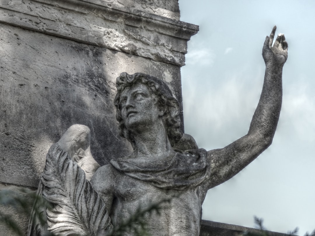 Stone angel statue with arm raised towards sky