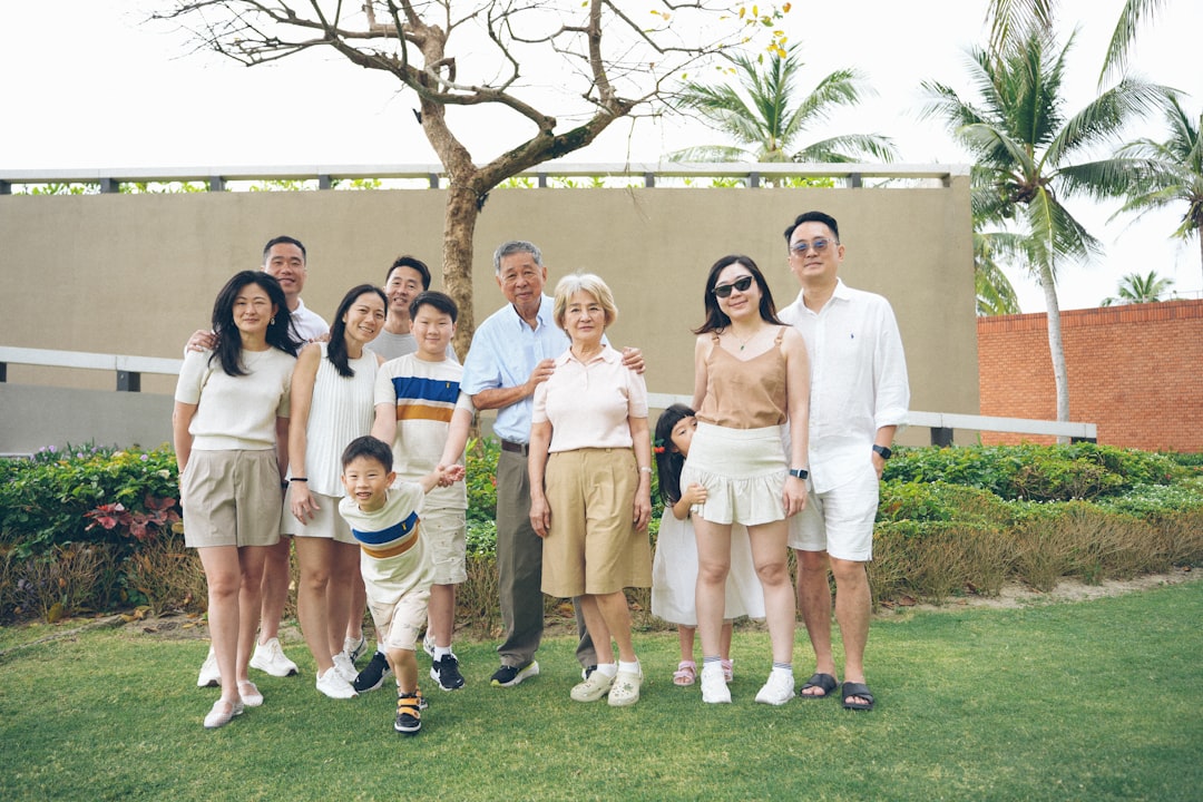 A multi-generational family poses for a group portrait outdoors.