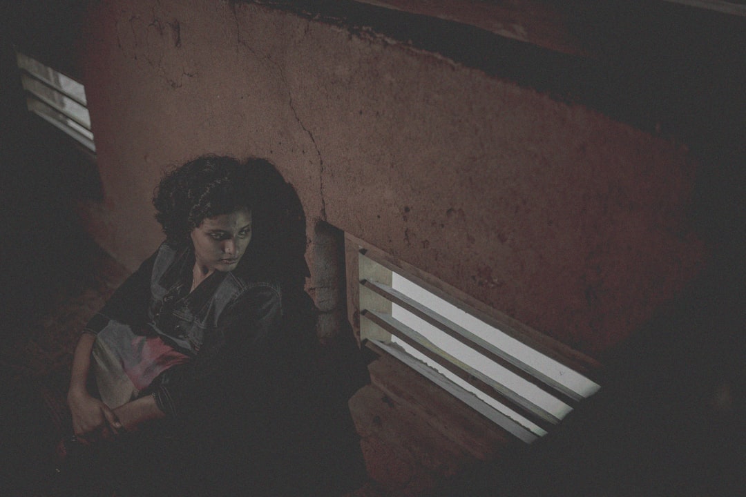 woman in black jacket sitting on white wooden bench